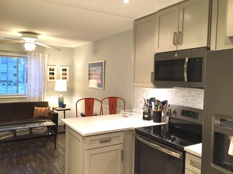 Renovated and fully stocked kitchen with custom back splash and breakfast bar.