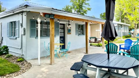 Patio with Adirondack chairs, charcoal grill, fire pit, picnic table and swing.