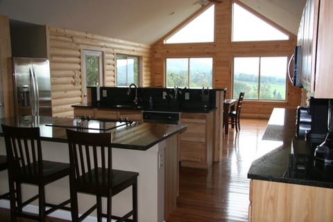 large kitchen with stainless steel appliances and black granite counter tops.