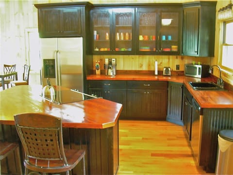 Wooden counters in Kitchen with Stainless Appliances and Island with Barstools