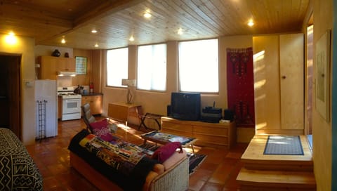 First floor studio view of living area and custom kitchen & solar windows.