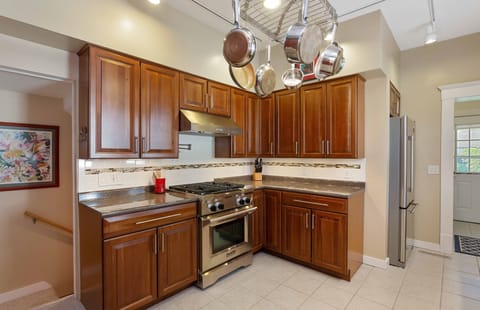 Fully equipped kitchen adjacent to laundry and outdoor grill area.