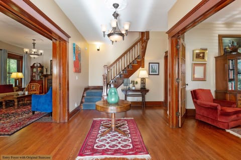 Welcoming center hall/foyer with original staircase and 3 sets of French doors