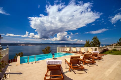 Modern and luxury property with heated pool, decked area, and 8 lounge chairs