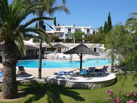 Pool with sun bathing area and gardens