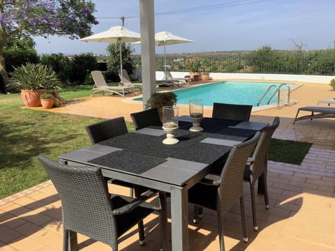 Shaded dining area overlooking the garden, pool and beyond