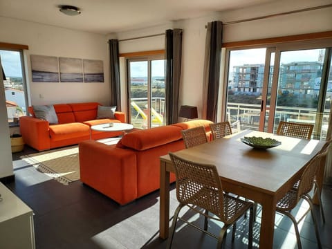Sun filled living room, opening up to the large front balcony and sea views!
