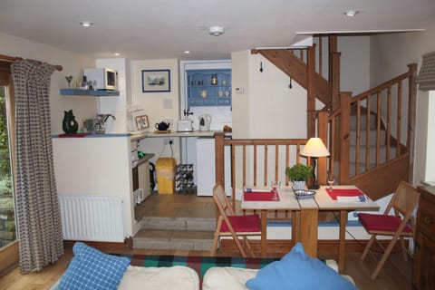 Galley kitchen with fridge, two zone hob, oven, small freezer and storage space.