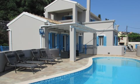 Pool with sun loungers and shaded seating area