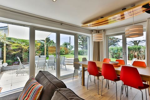 Large main living area with sofas, dining for 10, kitchen and doors to garden