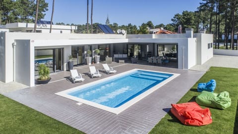 House surrounded by outdoor space, with swimming pool and garden.