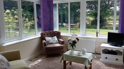 Bright and airy living room over looking the gardens and pond. 