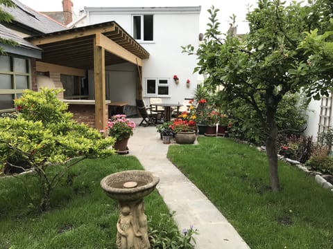 Garden and sheltered kitchen with wood fired pizza oven & BBQ. Path to shops.