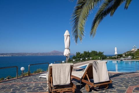 Seaside terrace with loungers and sweeping ocean views near the swimming pool