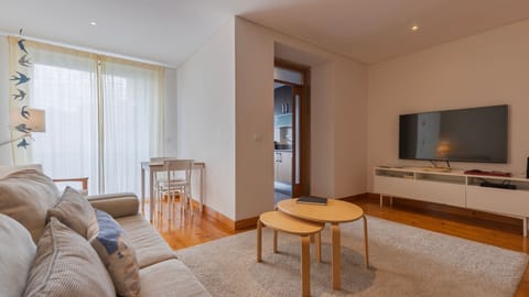 A cozy space with a comfortable sofa, flat-screen TV, and a compact dining table near the window to enjoy natural light. #cozy #apartment #lisbon