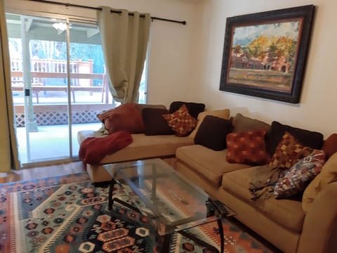 Living room has both this large sectional as well as a sofabed. Overlooks patio.
