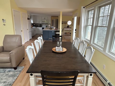 Dining room table seats 8-10, faces front of house by 4 windows.