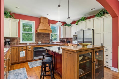 Open kitchen with six-burner range, double ovens, large fridge, and dishwasher