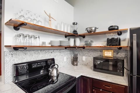 Well stocked kitchen with numerous cooking tools, small appliances and ample counter space for prep.