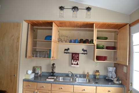 kitchen is fully stocked with plates, silverware and cookware