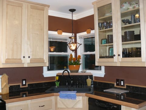 A corner sink and dishwasher.  Full set of dishes & glasses for 6 provided.