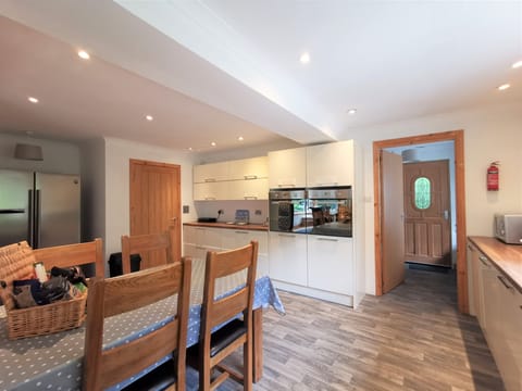 Kitchen, looking through to utility room and back door. Double ovens.