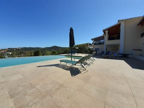 Pool are has sun loungers, a dining area and swing chairs