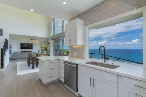Open-concept layout seamlessly connects kitchen, dining, and living areas with coastal views.
