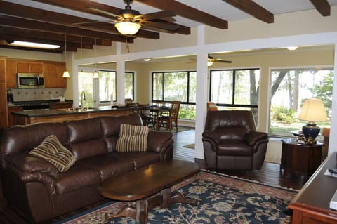 Big open floor plan with new leather furniture and recliner in front of TV