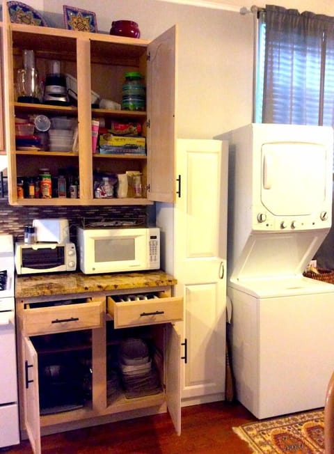 The kitchen is well stocked for cooking and the pantry holds cleaning supplies.