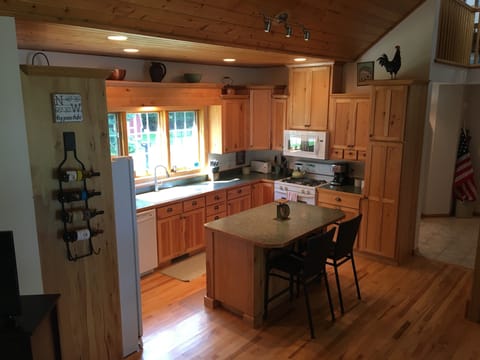 Fully stocked, open kitchen with wooded view