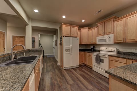 Kitchen with granite counters, fully stocked with utensils and cookware