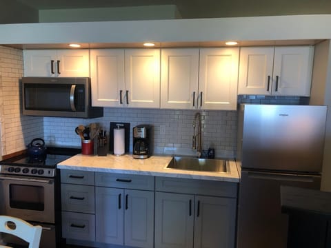 Fully renovated tiled kitchen with a new 4 burner glass top Whirlpool oven.