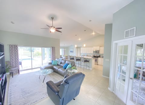 Bright open concept living with 13' ceilings and several pool views. 