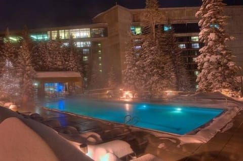 One of two heated outdoor pools with hot tubs.  Other on roof with no kids.