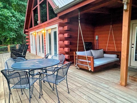 deck is partially covered. 2 dining sets. rocking chairs. couch swing. hot tub.