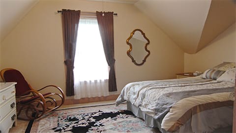Master bedroom with queen-sized bed and view over the town.