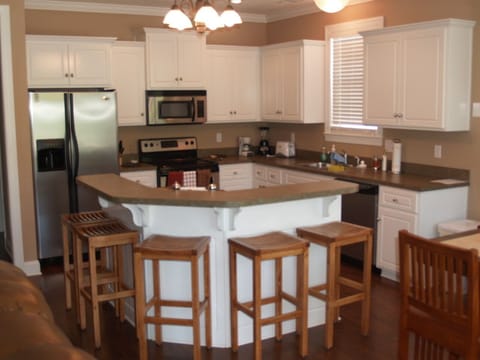 Kitchen with stainless steel appliances, island bar seats five.
