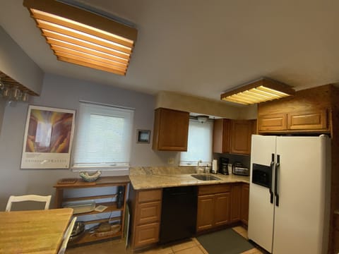Kitchen fully equipped with china and wine glasses.