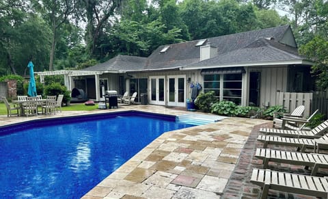 Rear view of home with fenced back yard and pool