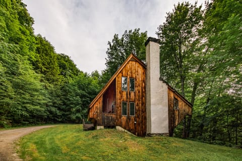 View of the house from the driveway.  On over an acre, surrounded by trees.