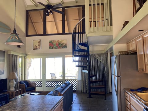 View from kitchen of living area, spiral stair to loft, and outside
