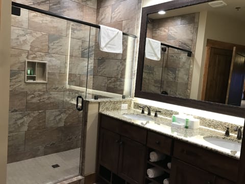 Large bathroom with vanity and double sinks and shower.