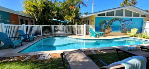 Gated Heated Swimming pool area with lounge and Adirondack chairs. 