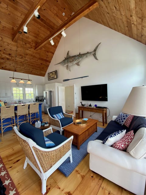 The wide open living room has a large screen TV and comfy furniture.