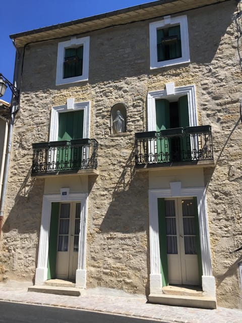 The front of the house with 2 balconies on the first floor.