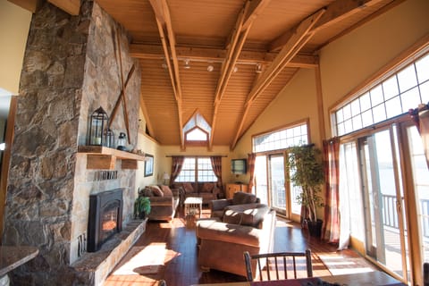 Livingroom with natural stone fireplace and panoramic views of the lake!