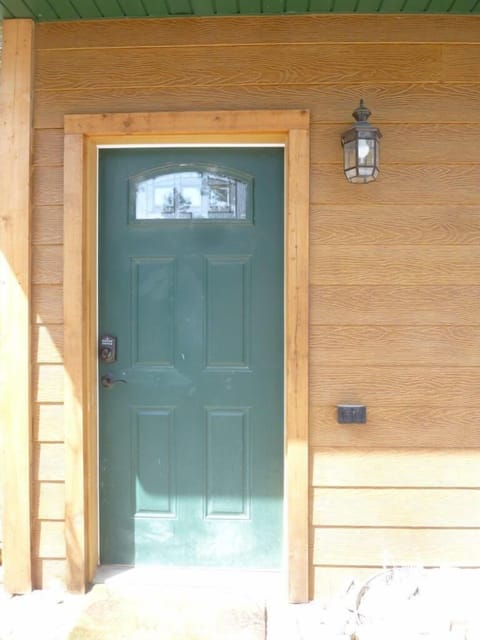 Entrance to left of garage doors.