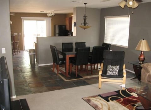 Open floor plan with natural slate flooring and granite dining table.