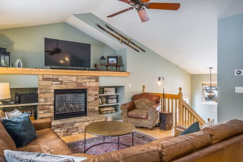Sunny living room with fireplace, 55" TV, & sound bar.